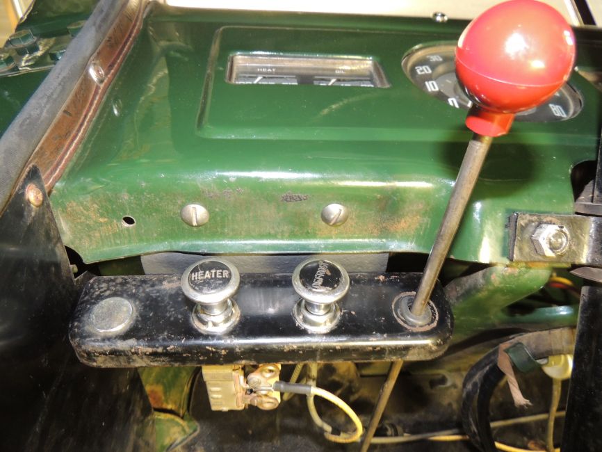 Model 61, 62, and 65 control panel and mounting bracket #1
Looking up and towards the underside of the dash. Mounted between driver's side kick panel and steering column. Showing heater and defroster knobs as well as the Monarch snowplow pump control rod currently occupying the extreme right hand side hole.
